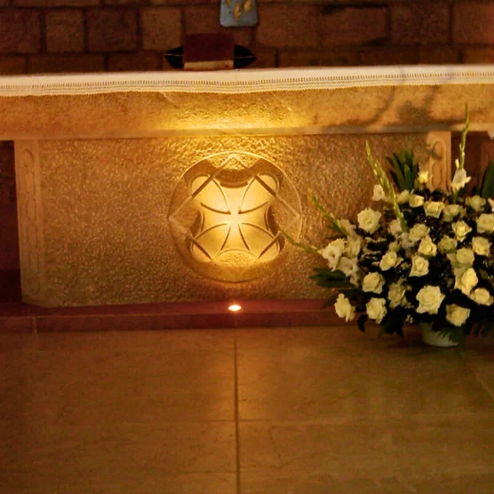 Carved stone altar with a cross motif in a church sanctuary