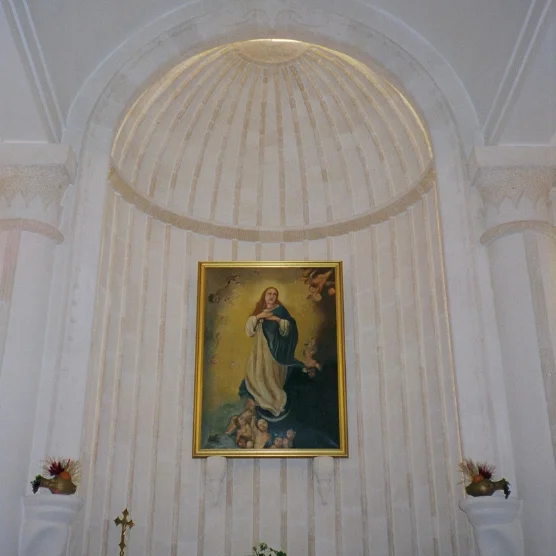 Marble niche with a fluted half-dome framing a painting of the Virgin Mary
