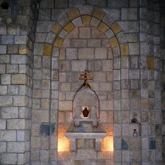 Stone church wall with an arched niche and carved tabernacle
