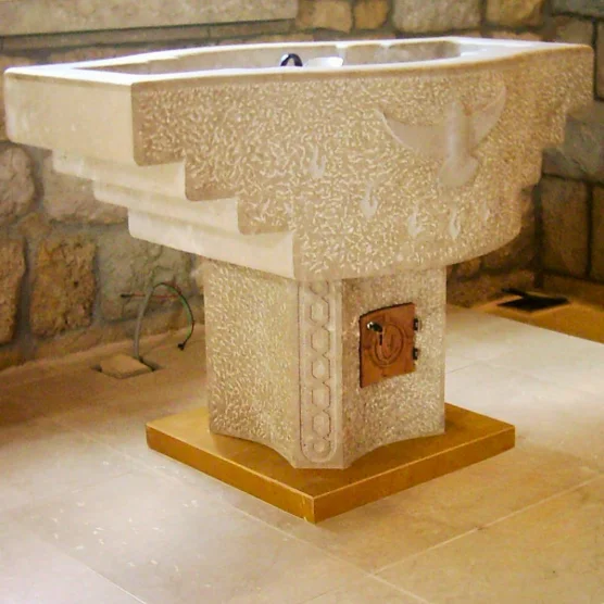 Hand-carved stone font with relief decoration